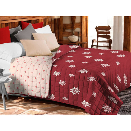 Rote Edelweiss Steppdecke mit weißen Blumen auf rustikalem Bett